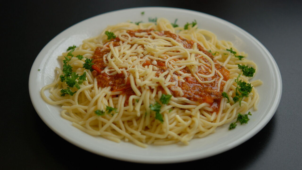 Bolognese vom Schwein (A, A1, F, I) mit Spaghetti (A, A1), dazu geriebener Käse (G)