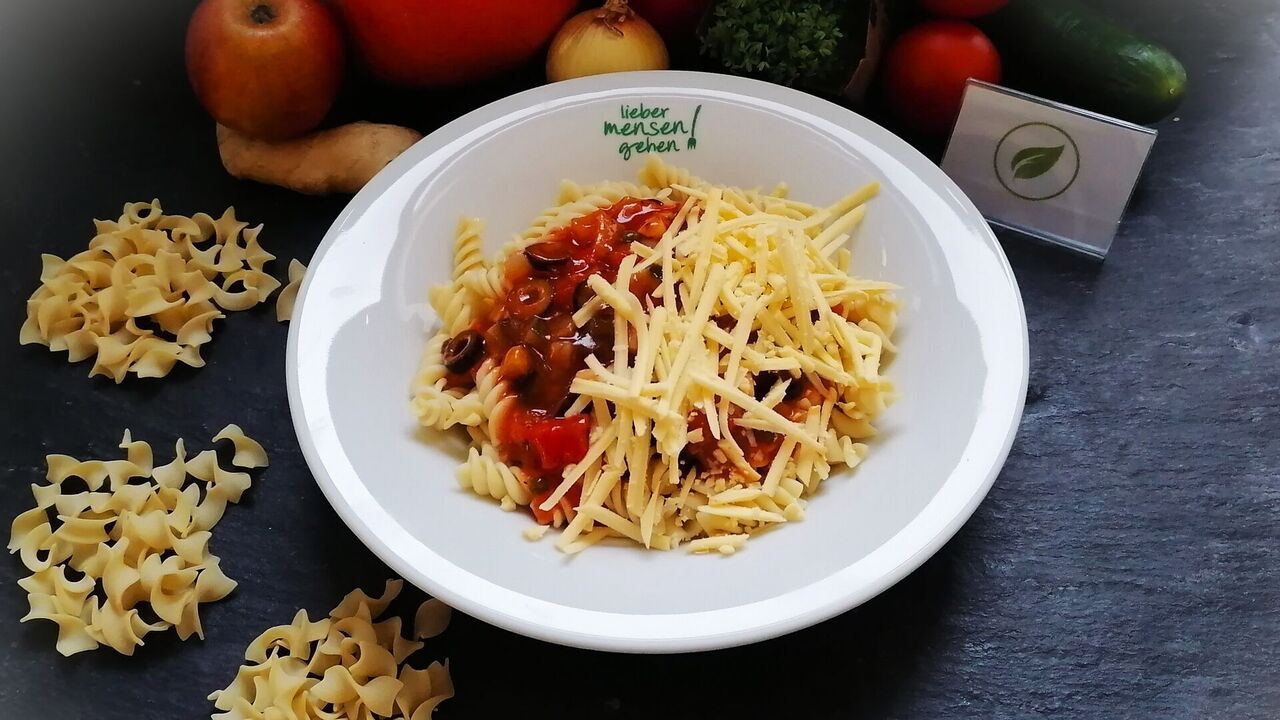 Nudeln (A, A1) mit Pastasoße alla sicilliana (Tomate, Olive, Zucchini, Kapern und Aubergine), dazu veganer Schmelz oder geriebenen Käse (G) (dann nicht mehr vegan)