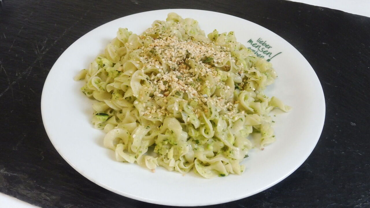 Hausgemachte vegane Pasta (A, A1) mit Zucchini-Minzpesto (L) und Cashewkern-Sesamtopping (H, H4, K)