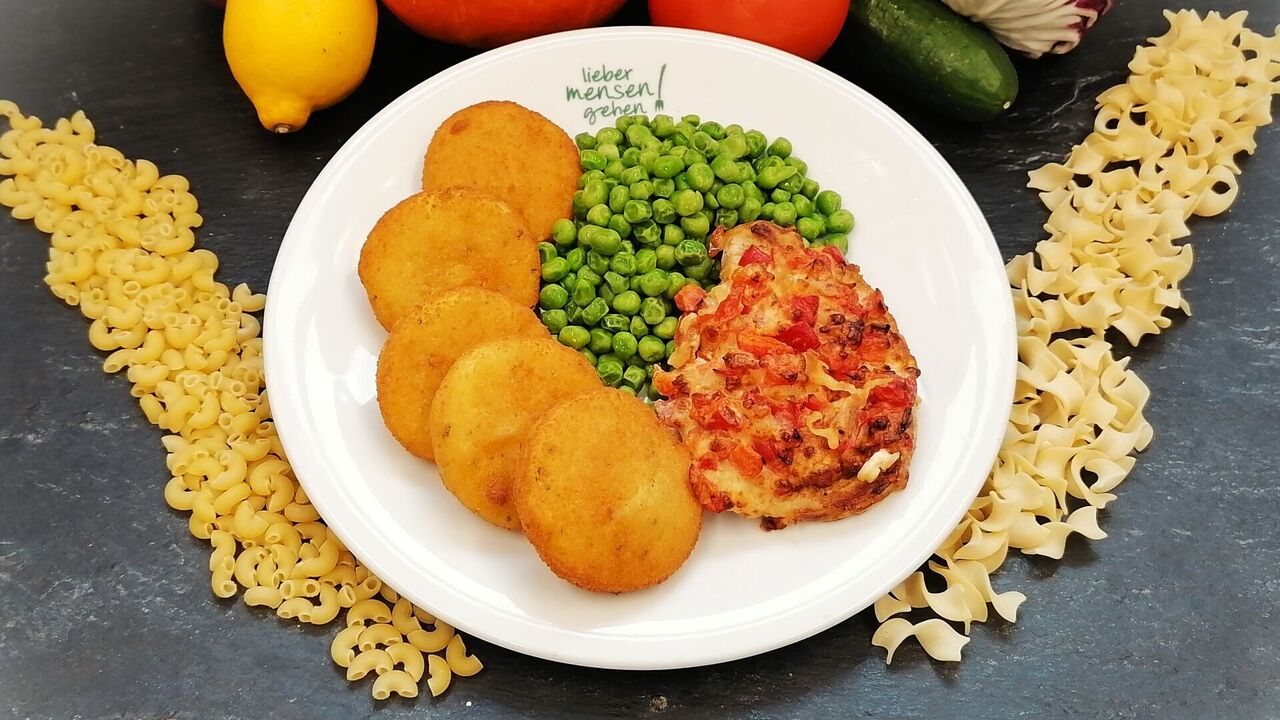 Gebratenes Rückensteak mit Paprika, Tomaten, Zwiebeln und Käse gratiniert (A, A1, G), dazu Erbsen und Macairekartoffeln (A, A1)