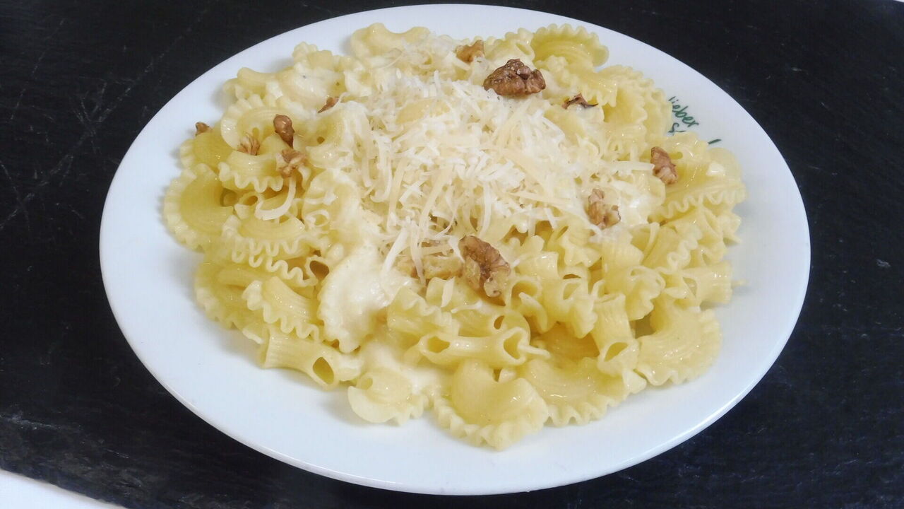 Hausgemachte Pasta (A, A1, C) mit Gorgonzola, Birnen und Walnüssen (A, A1, G, H, H3), dazu gehobelter italienischer Hartkäse (G)