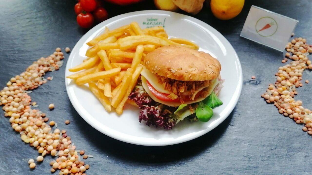 Burger mit Mozzarella, Tomate, Rucola und Basilikumpesto (A, A1), dazu Parmesancreme (C, G, J, F) und Pommes frites